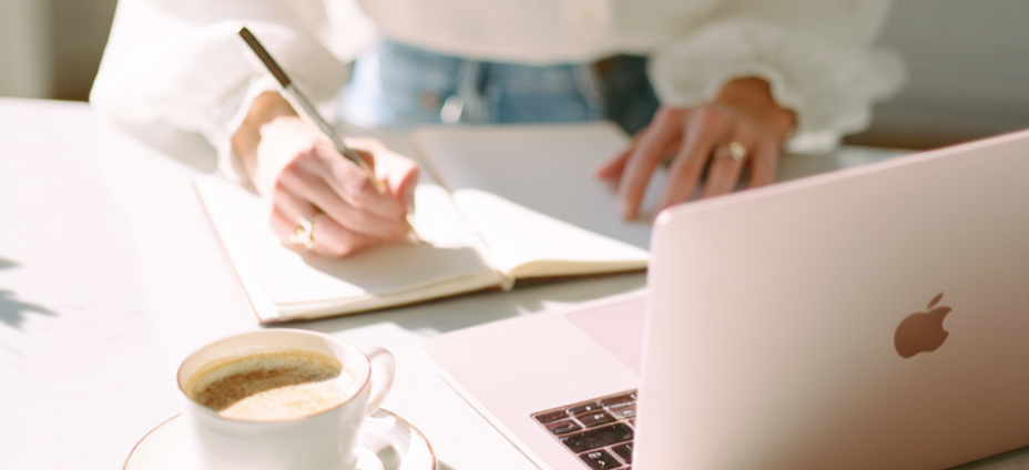 Person working on a laptop with a cup of coffee on a desk
